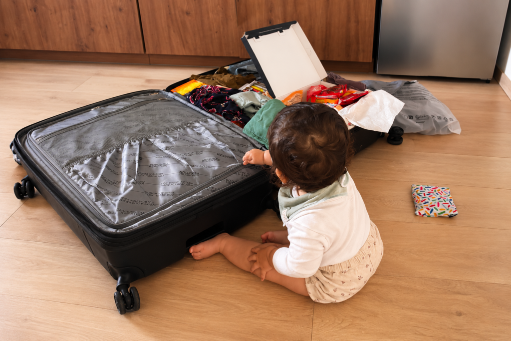 Bebé junto a una maleta antes de viajar en avión